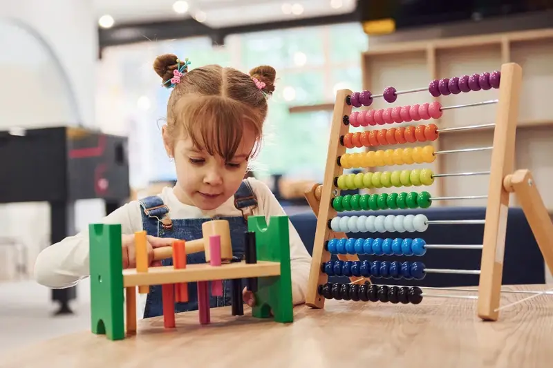 Cérebro infantil: estimular sem exagero — menina brincando com brinquedo educativo e ábaco